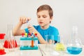 Little smart scientist doing chemical experiments in laboratory