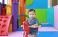 Little smiling baby boy playing horse on playground, wooden rocking Royalty Free Stock Photo