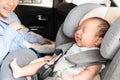 Asian little smiling baby child fastened with security belt in safety car seat Royalty Free Stock Photo