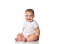 Little baby girl in white bodysuit sitting on the floor isolated on white. Royalty Free Stock Photo