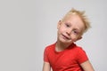 Little smiling blonde boy in red t-shirt. Portrait. Space for text. White background