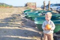 Little boy holding pumpkin near wheelbarrows at farm field patch Royalty Free Stock Photo