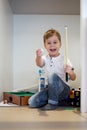Little smiling boy is playing on a floor at home in billiards