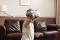 Little smiling boy wearing VR goggles using a controller for interaction in a game