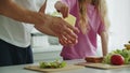 Little smiling daughter stands in the kitchen at the table and helps her father to prepare and fold a sandwich for