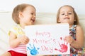 Little smiling girl and boy holding a picture of congratulations Happy Mother`s Day made by her hand indoors. Kids Royalty Free Stock Photo