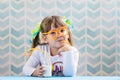 Little smiling girl drinking milk with funny glasses straw Royalty Free Stock Photo