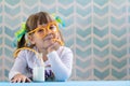 Little smiling girl drinking milk with funny glasses straw