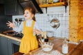 Little happy girl playing around in the kitchen.