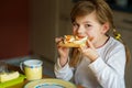 Little smiling girl have a breakfast at home. Preschool child eating sandwich with boiled eggs. Happy children, healthy Royalty Free Stock Photo