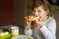 Little smiling girl have a breakfast at home. Preschool child eating sandwich with boiled eggs. Happy children, healthy food and Royalty Free Stock Photo