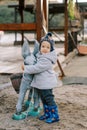 Little smiling girl hugging pack donkey statue