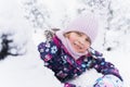 Little smiling girl, kid walking in beautiful winter forest, park among trees, branches covered with snow. Pink hat, scarf, snood Royalty Free Stock Photo