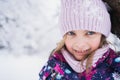 Little smiling girl, kid walking in beautiful winter forest, park among trees, branches covered with snow. Pink hat, scarf, snood Royalty Free Stock Photo