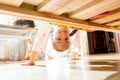 Little smiling girl looking under bed Royalty Free Stock Photo