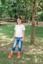 Little smiling girl model in white shirt posing in park