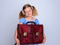 Little smiling girl with old satchel