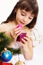 Little smiling girl opening christmas present