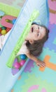 Little smiling girl playing lying in ball park. Close up, portrait Royalty Free Stock Photo