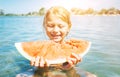 Little smiling girl portrait eating a red watermelon while she enjoying a splashing in river waves on the beach Royalty Free Stock Photo