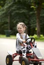 Little smiling girl in racing car amusemant park Royalty Free Stock Photo