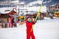 Little girl in red overall using button lift in ski resort in Bakuriani, Georgia Royalty Free Stock Photo