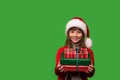 A little smiling girl in a Santa hat is holding a lot of gift boxes. New Year's gifts for Christmas. 2023. Isolated Royalty Free Stock Photo