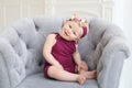 Horizontal photo of baby sitting in a chair on a light background Royalty Free Stock Photo