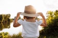 Little smiling girl in straw hat is having fun on summer holiday vacations. Happy child playing by the lake. Kid having Royalty Free Stock Photo