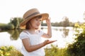 Little smiling girl in straw hat is having fun on summer holiday vacations. Happy child playing by the lake. Kid having Royalty Free Stock Photo