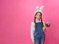 Little smiling girl wearing cute easter bunny ears smiling with happy face holding a bouquet of flowers. Copy space. Royalty Free Stock Photo