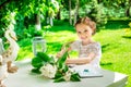 Little smiling girl writing on notebook outdoor in the park. Vi Royalty Free Stock Photo