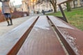 Little snow on city wooden bench in Warsaw