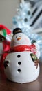 Little snowman in front of silver blong christmas tree