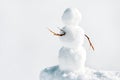 Little snowman with twigs standing in the icy snow, copyspace
