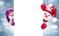 Little snowmen in caps and scarfs on winter background. Background with a funny snowmen. Christmas card. Royalty Free Stock Photo