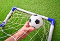 Little soccer ball in a father`s hands in a football goal Royalty Free Stock Photo