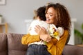 Young mixed race woman mother with flower bouquet embracing son while getting congratulations on Mother`s day Royalty Free Stock Photo