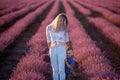 Little son hides behind mother. Young woman and boy walk through the rows of lavender purple field Royalty Free Stock Photo