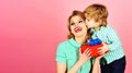 Little son kisses happy mother and gives her present box. Mother's day celebration. Family holidays. Child boy Royalty Free Stock Photo