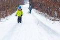 Little son with mother sliding in the snow in winter park. Happy young family enjoying a sledge ride. Winter holidays. Young happy Royalty Free Stock Photo