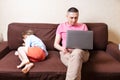 Little Son Offended To His Father Busy With Laptop. Man and kid boy sitting on couch. Cute child sitting back and angry