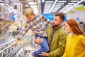 little son show something delicious to parents in store
