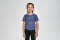 Little sportive girl child in sportswear smiling at camera, while standing isolated over white background Royalty Free Stock Photo