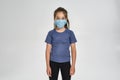 Little sportive girl child in sportswear wearing medical mask while standing isolated over white background Royalty Free Stock Photo