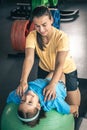 Cute child girl stretching on pilates fitness ball with mom in gym. Royalty Free Stock Photo