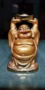 A little statue of Laughing Buddha in golden colour.