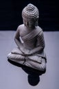 Little stone buddha statue on dark background