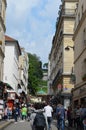 Little street with bunch of people walking on it