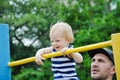 Little strong baby with his father playing sports outdoor. Children during his workout.